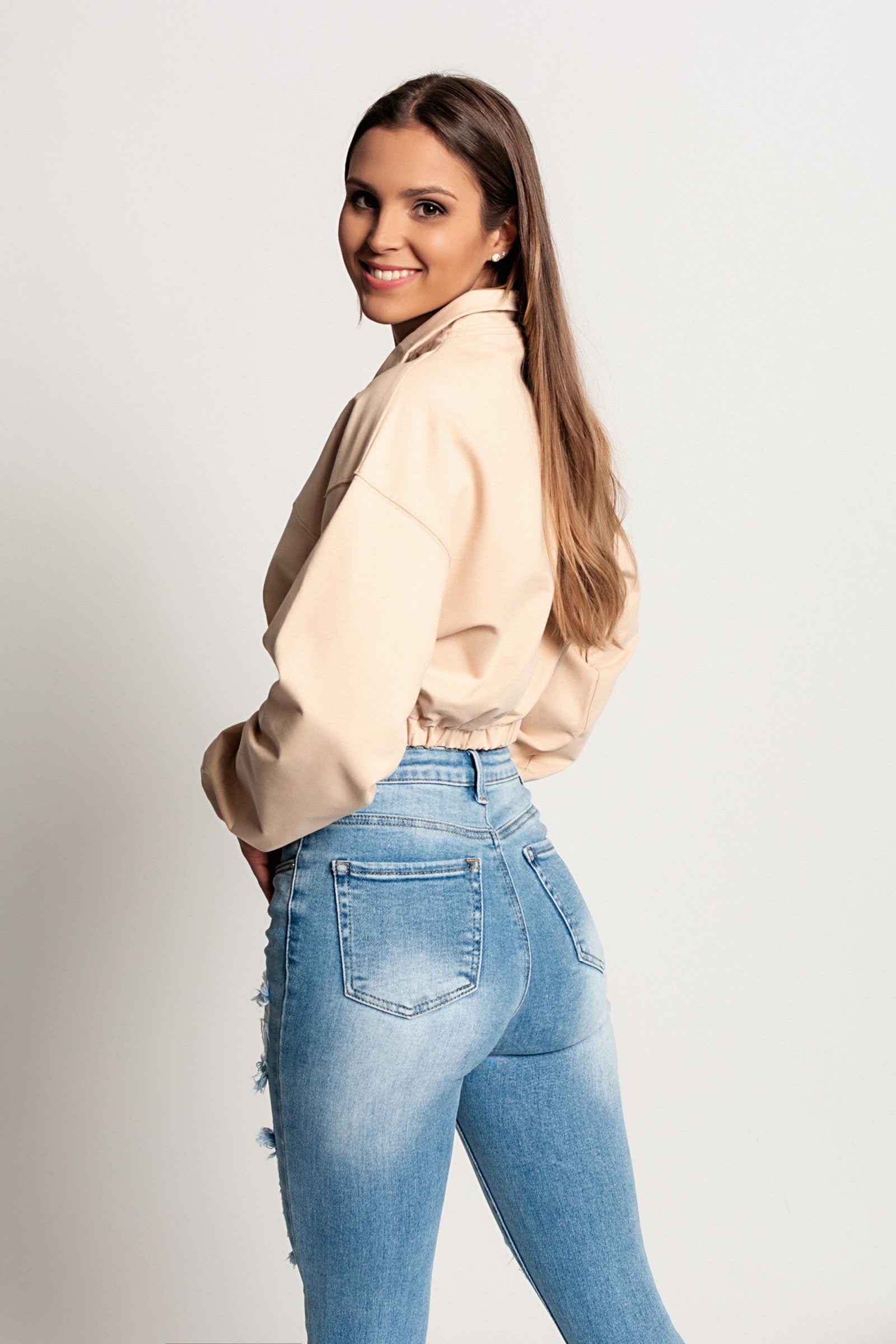 Skrajšana športna majica Polistena v bež barvi z dolgimi rokavi in visokim ovratnikom z zadrgo.